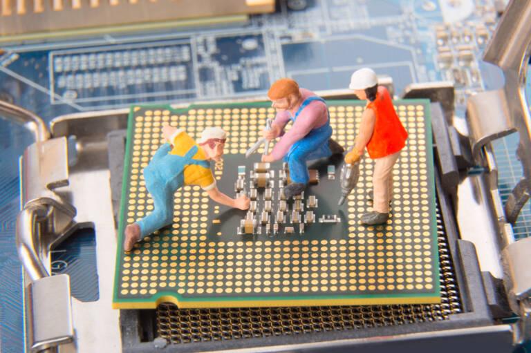 Miniature engineers or technician workers repairing CPU on the motherboard. Computer service and technology concept